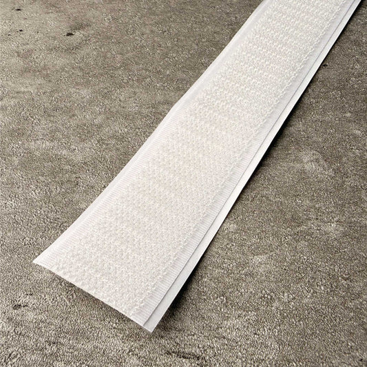 A close-up of velcro hook side, shown on a grey concrete surface.